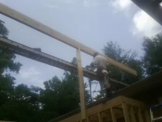 Carpenter setting a ridge beam over a new addition frame — Ice Dam Removal by Roofing Brothers in Vina
