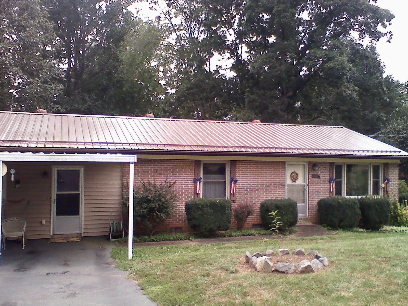 Bronze metal roof and carport on a brick ranch home — Roof Repair work by our crew in Vina